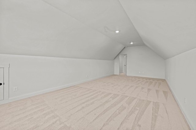 bonus room featuring light carpet, lofted ceiling, and baseboards