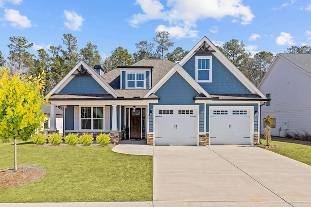 craftsman-style home featuring concrete driveway, a front lawn, and stone siding