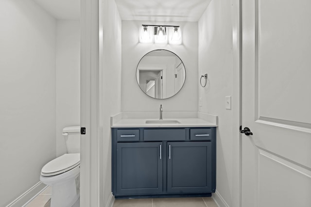 bathroom with baseboards, vanity, toilet, and tile patterned floors