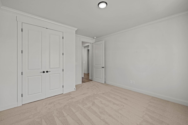 unfurnished bedroom featuring baseboards, carpet floors, and crown molding