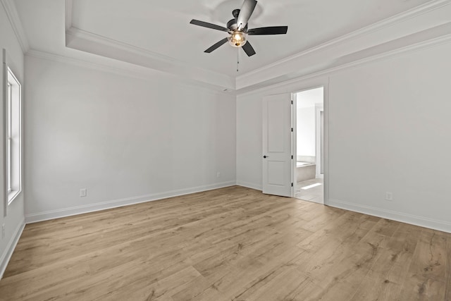 unfurnished room featuring a tray ceiling, light wood-style floors, ornamental molding, ceiling fan, and baseboards