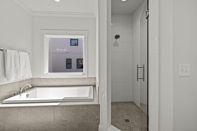 bathroom with a stall shower, crown molding, and a bath