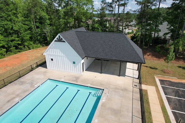 pool featuring a patio, a yard, and fence