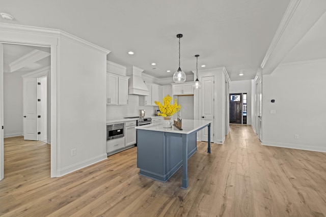 kitchen featuring a kitchen island, white cabinetry, light countertops, custom exhaust hood, and crown molding