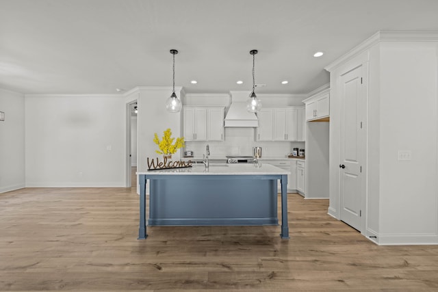 kitchen with custom exhaust hood, light countertops, crown molding, light wood-type flooring, and white cabinetry