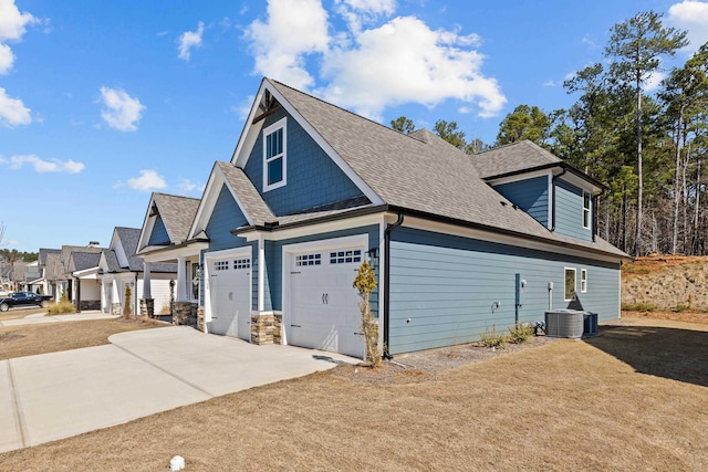 view of side of property featuring driveway and roof with shingles