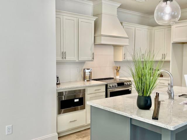 kitchen with custom exhaust hood, white cabinets, and stainless steel electric range oven