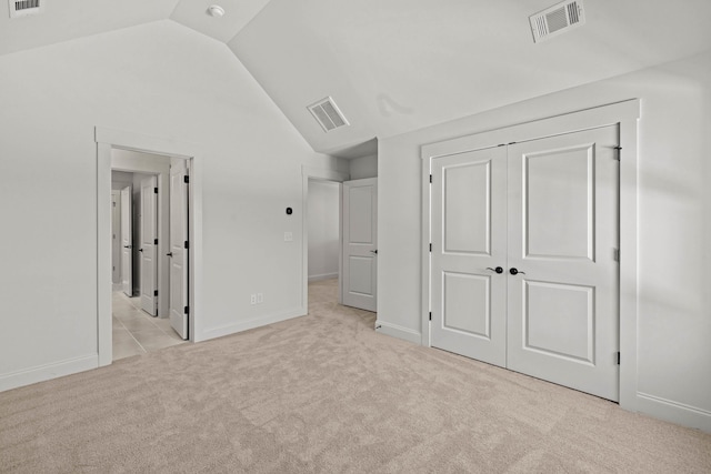 unfurnished bedroom with carpet floors, visible vents, and vaulted ceiling