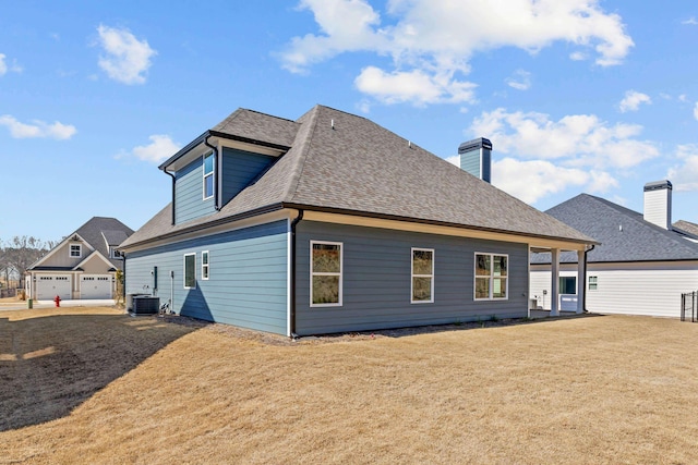 rear view of property with roof with shingles, a yard, and central air condition unit