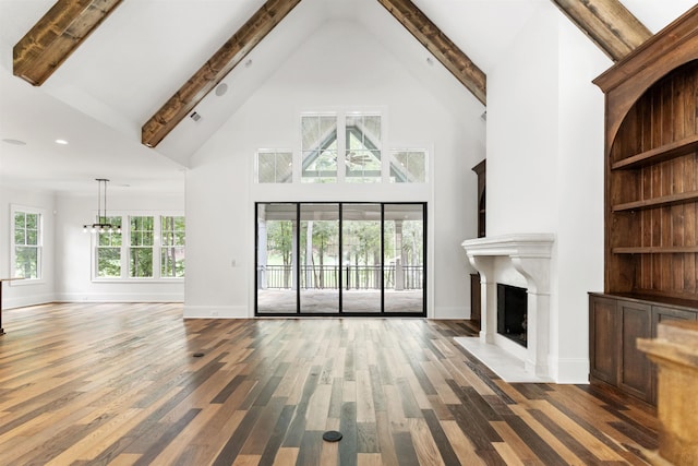 unfurnished living room with beamed ceiling, dark hardwood / wood-style flooring, built in shelves, and high vaulted ceiling