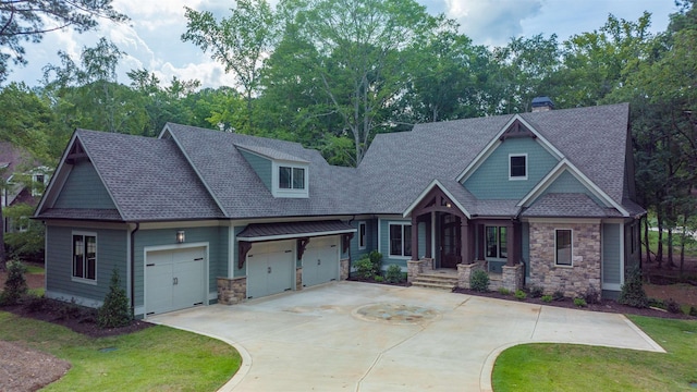 craftsman inspired home with a garage and a front lawn