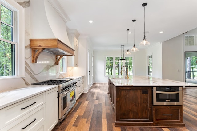 kitchen with sink, stainless steel appliances, white cabinets, a center island with sink, and custom exhaust hood