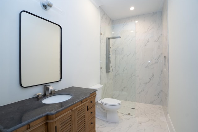 bathroom with tiled shower, vanity, and toilet