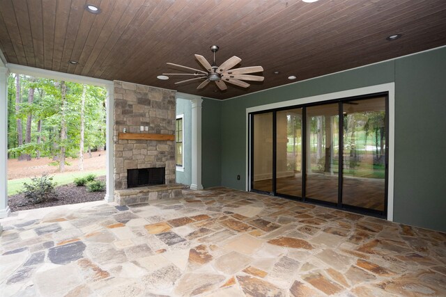 view of patio with ceiling fan and an outdoor stone fireplace