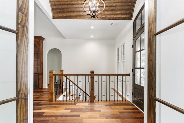 corridor with an inviting chandelier and hardwood / wood-style flooring