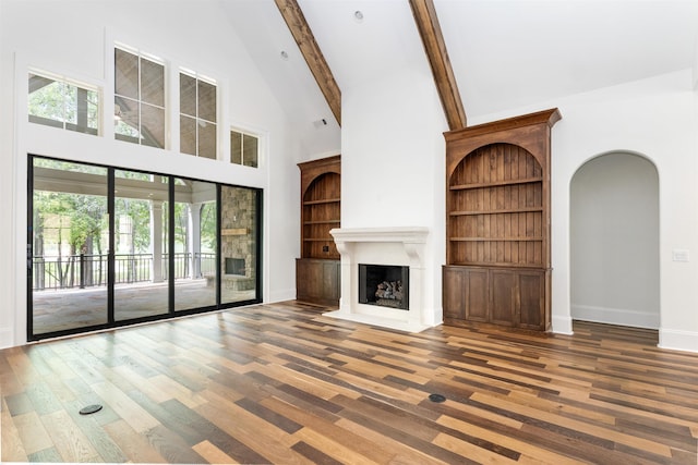 unfurnished living room with dark hardwood / wood-style flooring, high vaulted ceiling, and beamed ceiling