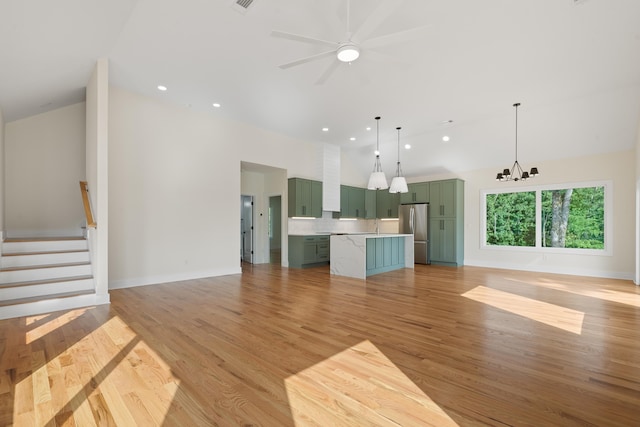 631 Susan Davis Rd, Sparta, GA 31087 - unfurnished living room featuring high vaulted ceiling, a chandelier, light wood-style floors, stairway, and baseboards