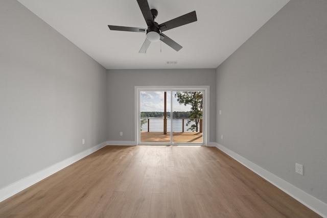 631 Susan Davis Rd, Sparta, GA 31087 - spare room featuring light wood-style flooring, baseboards, a ceiling fan, and a water view