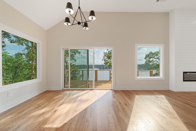 631 Susan Davis Rd, Sparta, GA 31087 - unfurnished room featuring plenty of natural light, a chandelier, baseboards, a fireplace, and high vaulted ceiling