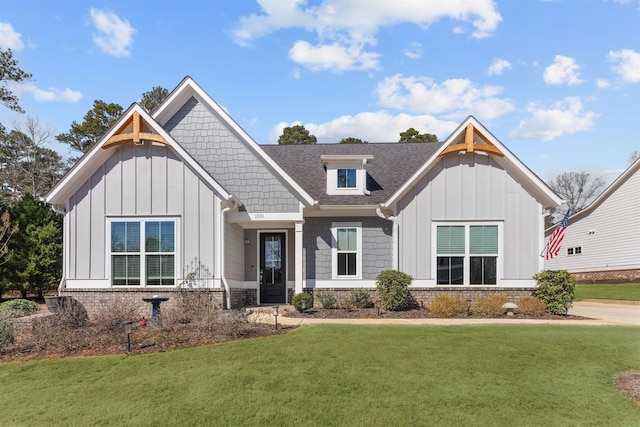 view of front of home featuring board and batten siding, a front yard, and roof with shingles