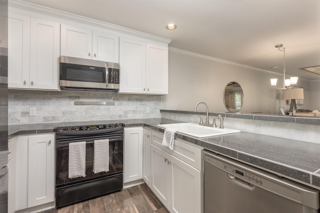 kitchen with appliances with stainless steel finishes, sink, white cabinets, decorative backsplash, and ornamental molding