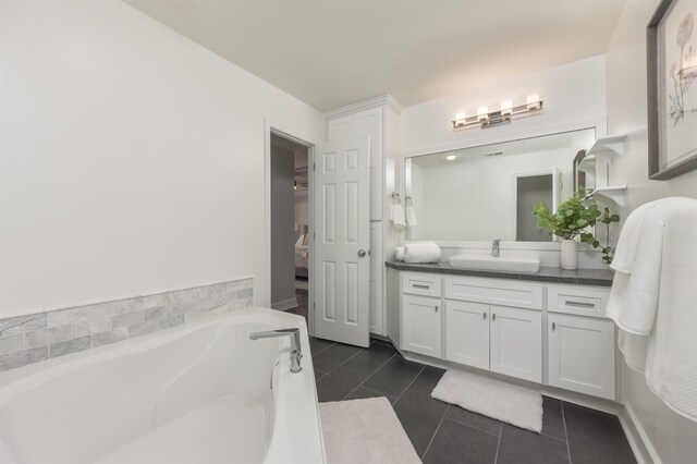 bathroom with tile patterned flooring, vanity, and a tub