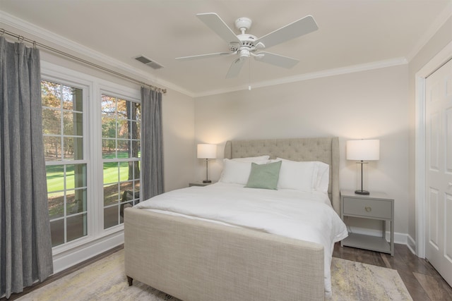 bedroom with crown molding, ceiling fan, and dark hardwood / wood-style flooring