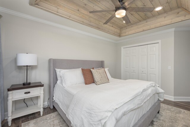 bedroom featuring dark hardwood / wood-style flooring, a raised ceiling, crown molding, wooden ceiling, and a closet