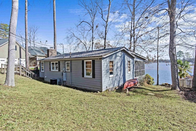 view of side of property featuring a lawn and a water view