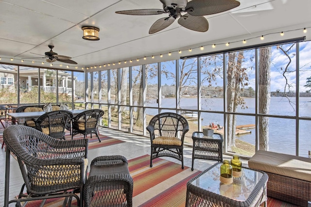 sunroom featuring a water view and ceiling fan