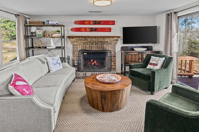 living room featuring a brick fireplace and ornamental molding