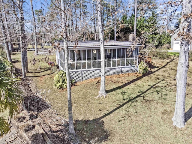 back of property featuring a lawn and a sunroom