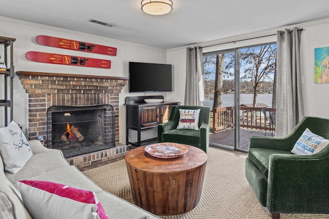 living room featuring ornamental molding and a brick fireplace