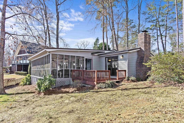 rear view of house with a lawn and a sunroom