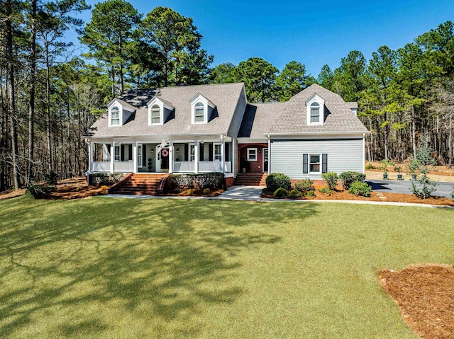 cape cod house with a porch, a front yard, and a shingled roof