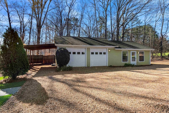 garage featuring a carport and dirt driveway