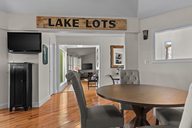 dining area with a wealth of natural light, baseboards, and light wood finished floors