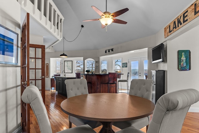 dining space featuring french doors, ceiling fan, baseboards, and wood finished floors