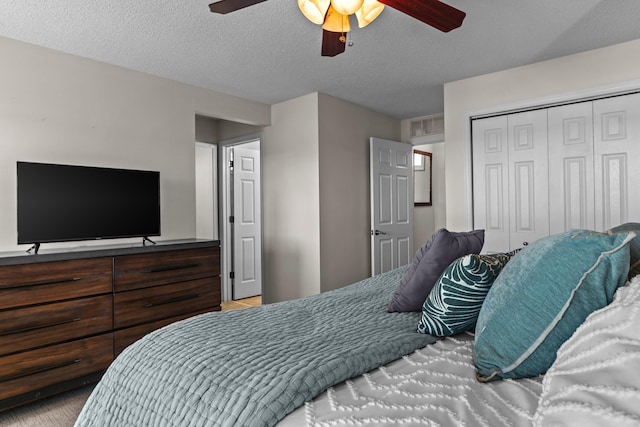 bedroom with a textured ceiling, ceiling fan, and a closet