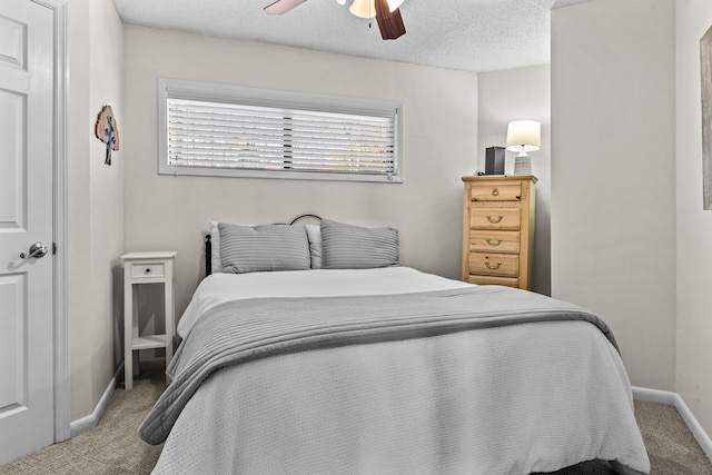 bedroom with a ceiling fan, carpet, baseboards, and a textured ceiling