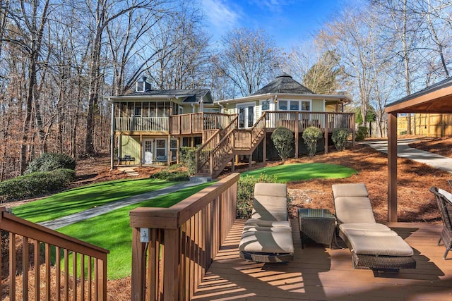 back of property with a sunroom, a yard, and a wooden deck