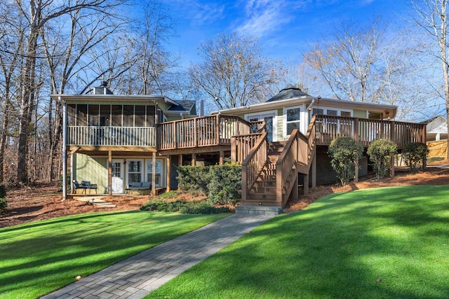 back of house with a sunroom, a chimney, a deck, and a yard