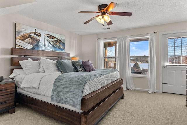 bedroom with visible vents, light carpet, ceiling fan, a textured ceiling, and baseboards