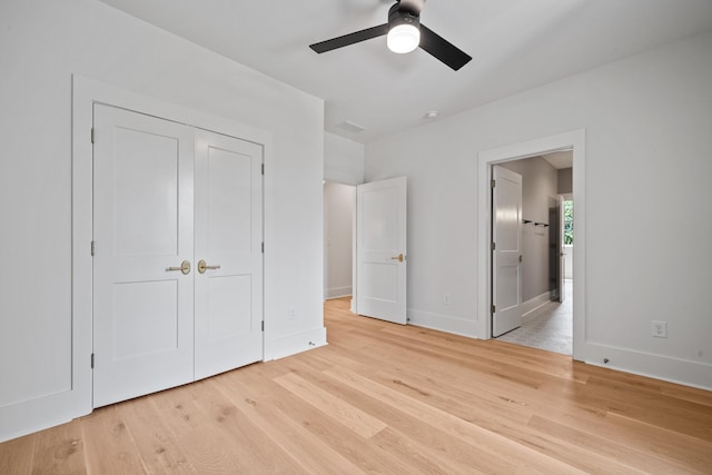 unfurnished bedroom featuring a closet, baseboards, connected bathroom, and light wood finished floors