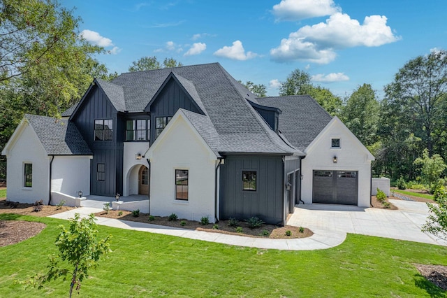 modern farmhouse featuring concrete driveway, a shingled roof, board and batten siding, and a front yard