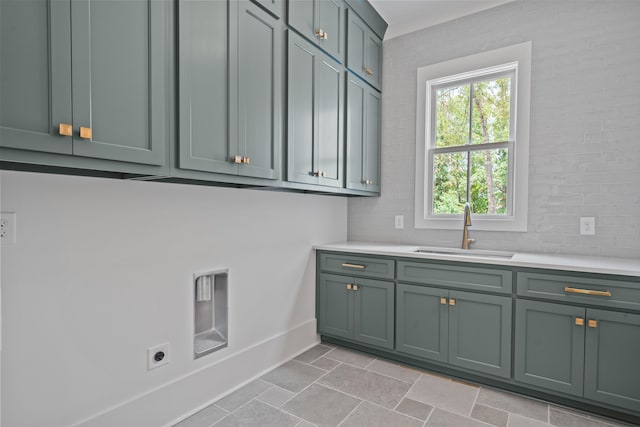 laundry room featuring cabinet space, stone finish floor, a sink, electric dryer hookup, and baseboards