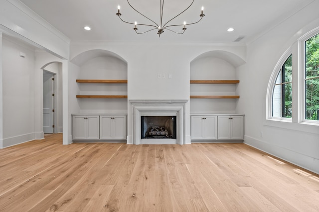 unfurnished living room with a healthy amount of sunlight, light wood-type flooring, and built in features