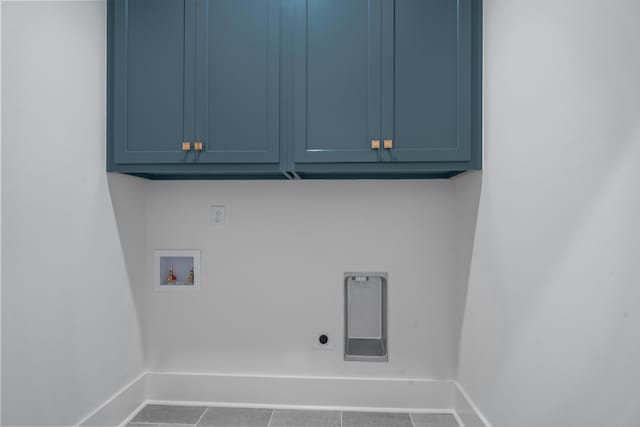 clothes washing area with hookup for a washing machine, cabinet space, electric dryer hookup, tile patterned flooring, and baseboards