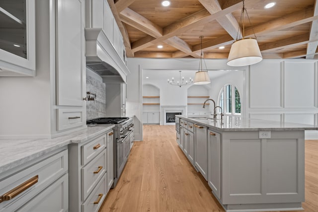 kitchen featuring range with two ovens, gray cabinets, a sink, light wood-type flooring, and coffered ceiling