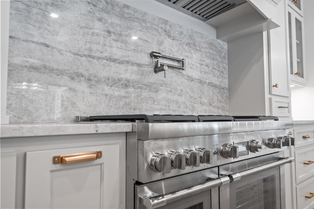 interior space featuring glass insert cabinets, white cabinetry, and double oven range